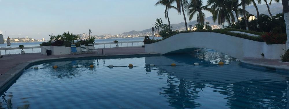 Sitting poolside at La Palapa admiring Acapulco Bay